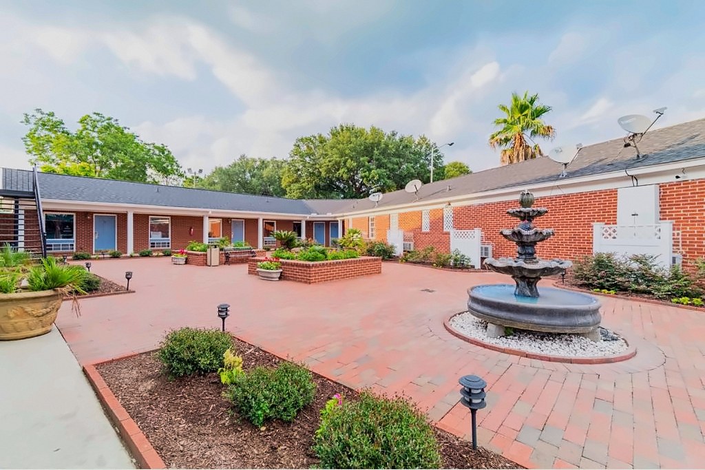 The courtyard fountain and brick pavers at Winton Inn & Suites on a cloudy afternoon