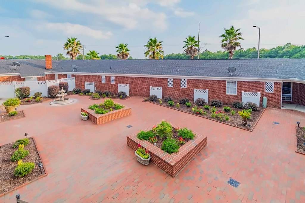 Garden beds set into the brick courtyard at Winton Inn & Suites